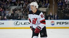 Ishockeyspelare i New Jersey Devils-matchställ på isen under en match.