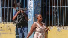 Kvinna i Haiti passerar en militärpolis utstationerad i huvudstaden Port-au-Prince.