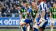 Fotbollsspelare i IFK Göteborg skjuter bollen under en match mot lag i grönsvarta tröjor.