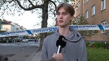 Person intervjuas framför polisavspärrning på gata i bostadsområde.