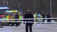 Polisavspärrning vid en väg med ambulanser och polisnärvaro i bakgrunden.