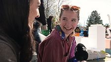 Två personer sitter utomhus och intervjuas av SVT, träd och folk syns i bakgrunden.