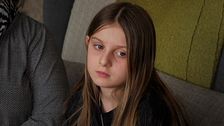 Nioåriga flickan Lisa med långt brunt hår sitter i soffa, berättar om känslorna kring  att utvisas till Albanien trots att hon är född i Sverige