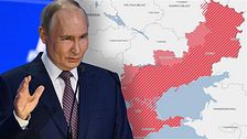 Man i kostym talar, bakom honom en karta med rödfärgade områden i östra Ukraina.