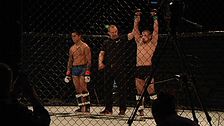Två MMA-fighters, domaren utser vinnaren som höjer händerna i oktagonen.