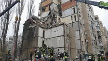 förstörd byggnad med räddningstjänst som jobbar