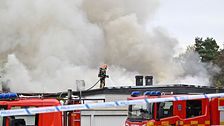 Brandman på taket och rök, brandbil framför hus