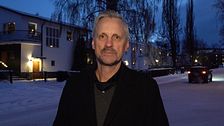 Bild på kommunpolisens Henrik Blusi utanför polisstationen i Sundsvall. I bakgrunden ser man att det är vinter och skymning och man ser ett hus.