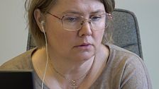 Tät bild på Karin Stierna där hon sitter på arbetshubben i Hammerdal. Blond kvinna med glasögon.