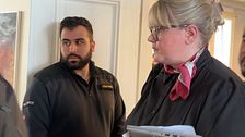 Moderatpolitikern Viktoria Jansson på väg ut ur fullmäktigasalen. En väktare tittar på.