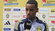 Person i svensk landslagströja intervjuas av SVT. Sponsorer synliga i bakgrunden.
