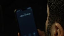 Person håller i smartphone med oidentifierat nummer på skärmen.