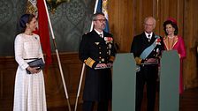 Danska och svenska kungahuset framför flaggor