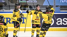 Tre ishockeyspelare från Vimmerby firar på isen.
