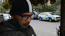 En man och en polisbil i Jordbro efter skjutningen.