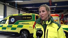 Kvinnlig personal framför ambulans