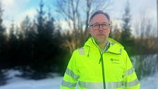 Jonas Mårtensson från SCA står med varseljacka, glasögon framför en skog i en snöigt landskap, utanför Östersund.