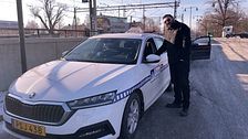 Man står bredvid en taxi. Han pratar med föraren genom fönstret.