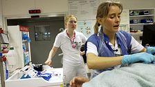 en läkare och en sköterska hjälper en sängliggande patient