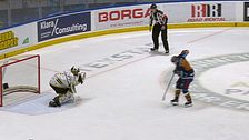 Hockeyspelare gör straffslag mot målvakt, domare står vid sidan och tittar på.