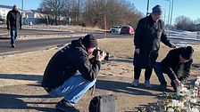 Länsmuseets fotograf Per Torgén fotograferar ett par som tänder ljus vid minnesplatsen vid Risbergska.