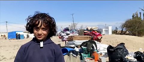 Pojke står vid tältlägret i Rafah.