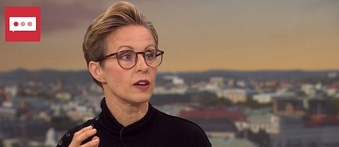 En kvinna med kort hår som syns med ansikte och överkropp.