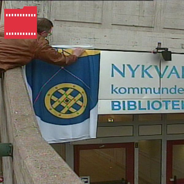 Man hänger upp Nykvarns kommunflagga, och kvinna som precis röstat