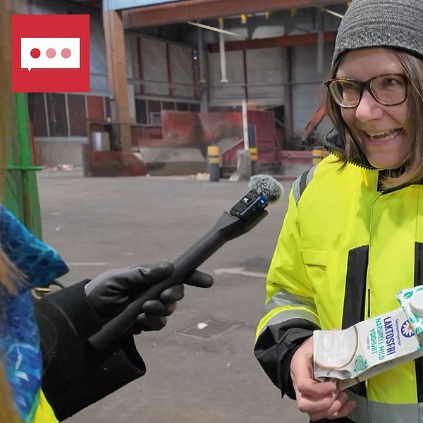 Reporter intervjuar person som håller en förpackning inne på en sopstation.
