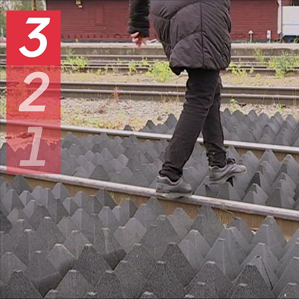 En person som går över ett järnvägsspår. Vid Spåren finns så kallade pyramidmattor som ska försvåra att personer genar över järnvägen