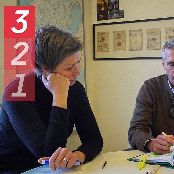 Tre lärare sitter runt ett bord i ett klassrum i Kungsbacka. På väggen hänger en karta över Sverige. På bordet ligger en pärm som lärarna tittar i.
