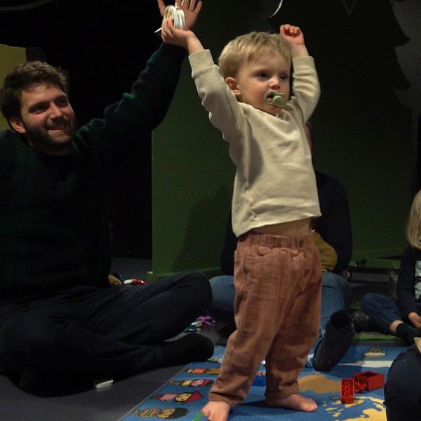 Vänster: Pappa med barn i en lekmiljö, barnet lyfter händerna  i luften, sångstund. Höger: Cecilia Albertsson stående utomhus framför en rödmålad byggnad, troligen i Grythyttan.