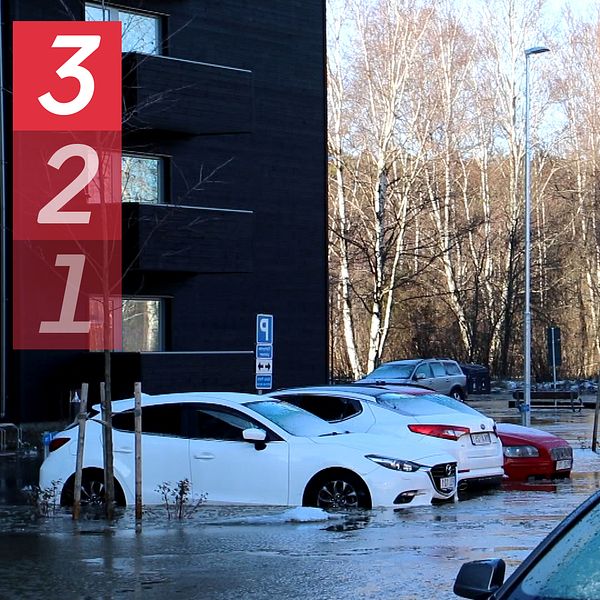 Bilar under vatten och skylt med siffrorna ett, två och tre