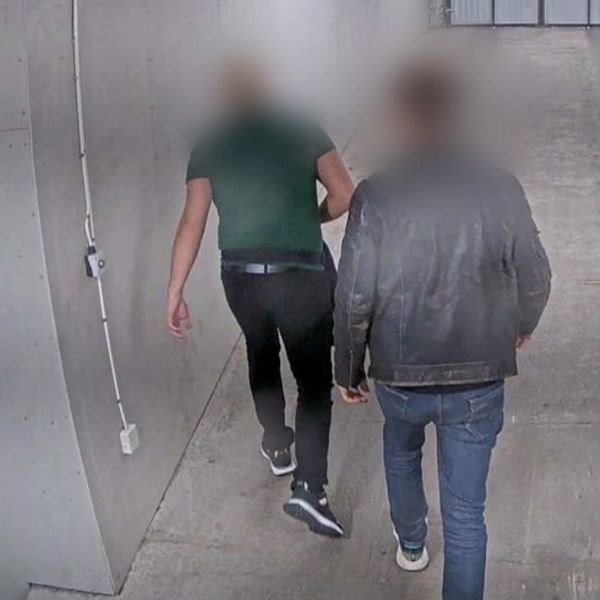 Bildens vänstra sektion visar två personer som går  genom en nedgång i en byggnad, med grå väggar och en enkel belysning, filmat från en övervakningskamera. Den högra sektionen visar en kvinna som står i Lunds tingsrätt framför en vägg med träpanel och moderna inredningsdetaljer, klädd i en svart jacka med knappar.