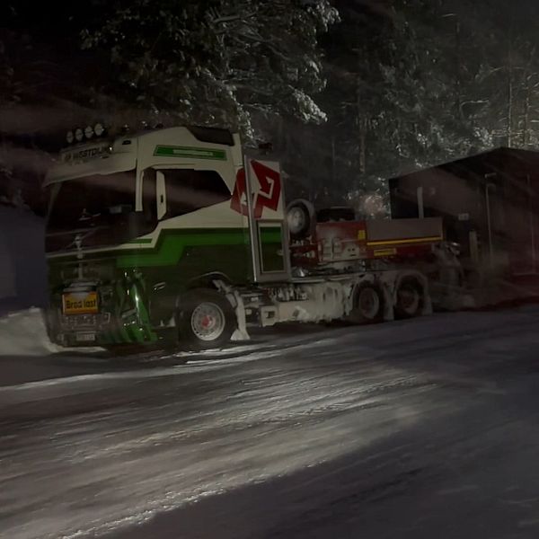 En lastbil står intill vägen i snöoväder