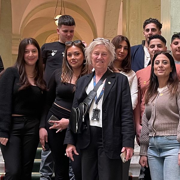 Ungdomar står i en trappa i riksdagen tillsammans med riksdagsledamoten Carina Ödebrink (S)