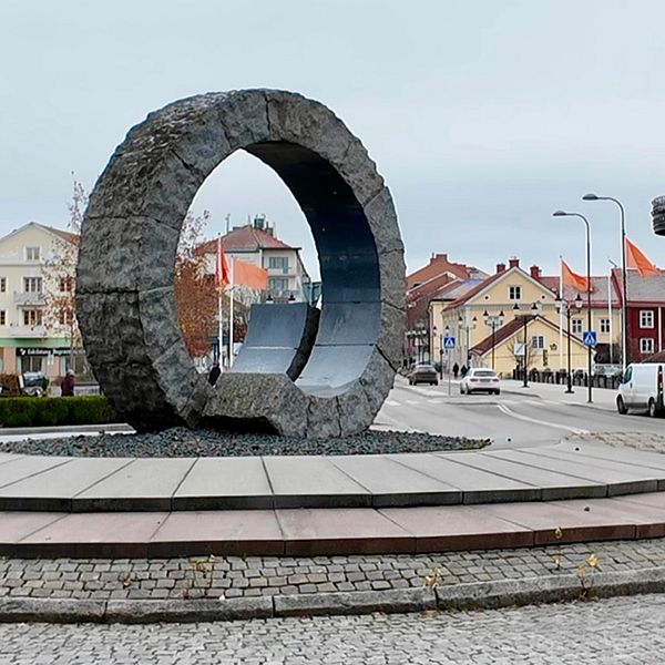 Delad bild. Till höger ett cirkelformat konstverk med orangea flaggor bakom, Till höger en kvinna i en korridor. Kvinnan har en orange tröja på sig