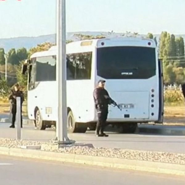En buss med militär framför och en man
