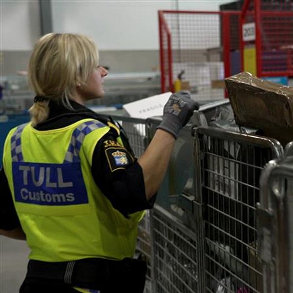 En delad bild som visar två scener relaterade till tullverksamhet. Den vänstra sektionen visar en tulltjänsteman som inspekterar en metallgallerbur fylld med ospecificerade föremål. Den högra sektionen visar en närbild av en kartong med fyrverkerier, märkta med ”MUTI 500”.
