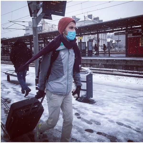 Ung kille går längst tågperrongen i Frankrike med resväska.