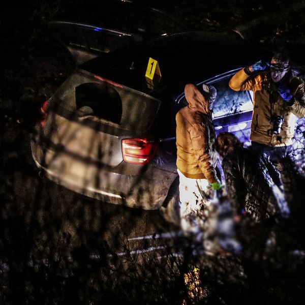 En brottsplatsundersökning i mörkret vid en bil