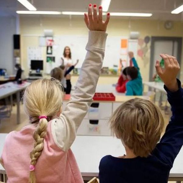 barn som räcker upp handen och kvinna i närbild