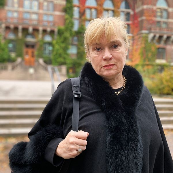 Docenten Annika Rejmer i svart kappa utomhus kommenterar fallet med Ray – mannen som tog sitt liv efter återkommande ha nekats akutboende av socialtjänsten i Göteborg