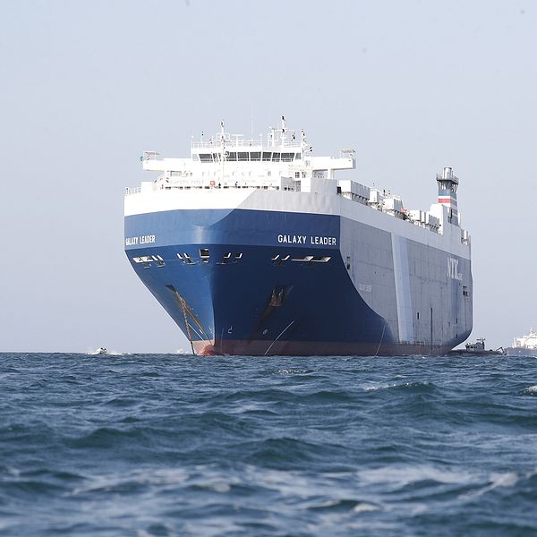 Stort fartyg på röda havet till vänster – man med glasögon till höger.