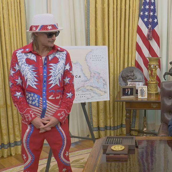 Donald Trump i Ovala rummet med man i färgglad dräkt stående bredvid.