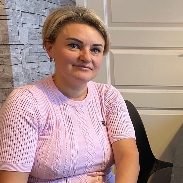 Tatiana, kvinna med  kort ljust hår vid en fikabord.