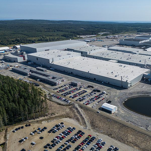 Till vänster: Flygbild på stor vit industrilokal med skog i bakgrunden. Till höger: Kvinna med mörkt hår iklädd vinröd tröja.
