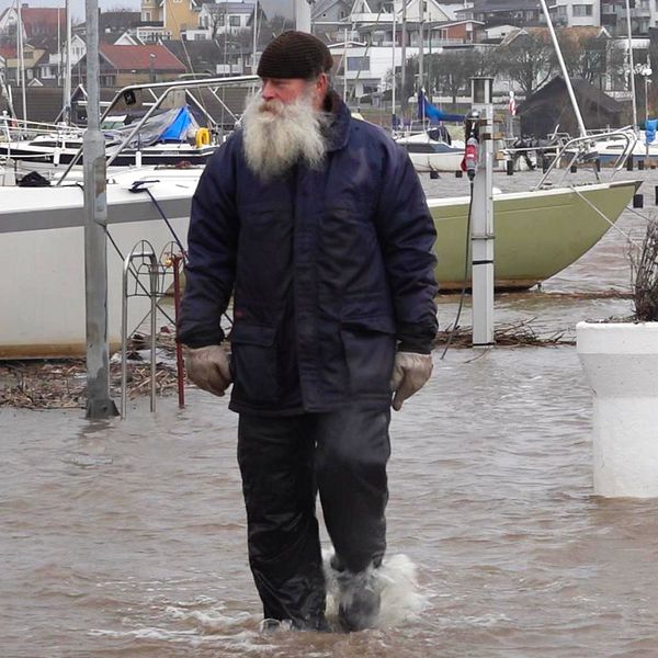 en båtägare går i översvämningen i ängelholm