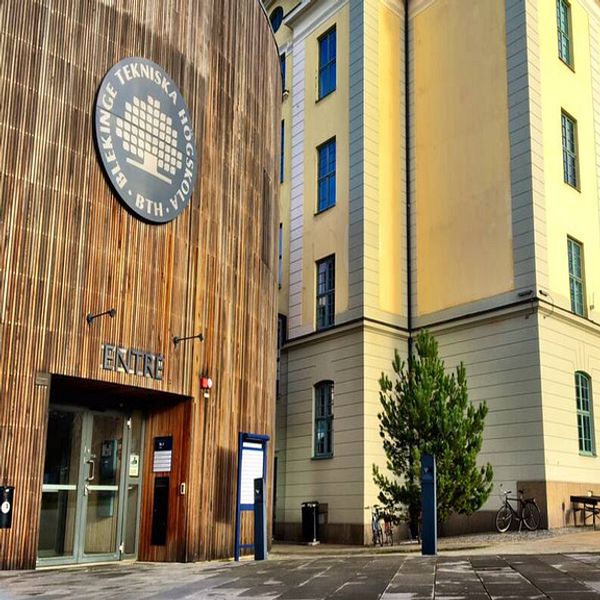 Gul putsfasad och brun träfasad tillhörande Blekinge tekniska högskola i Karlskrona.