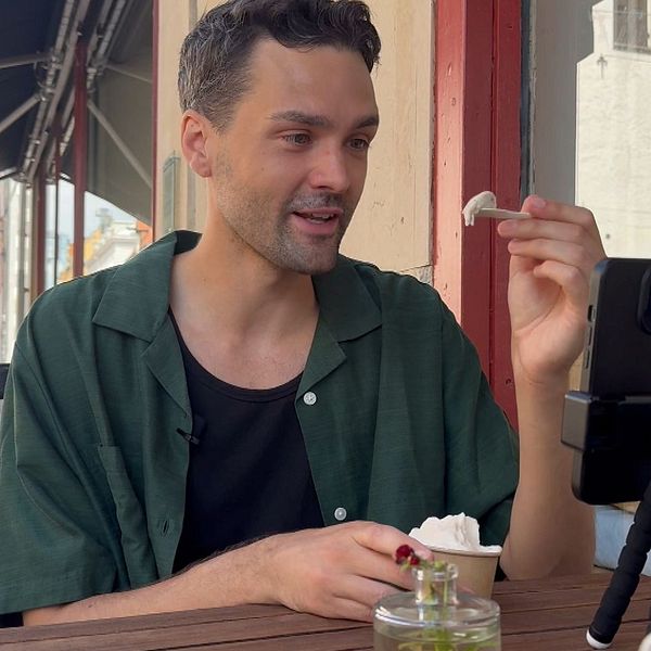 Rikard Lindholm äter bananglass på ett café i Kalmar och filmar upplevelsen.